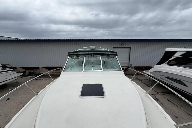 Slide: The Image of 1998 Pursuit 3400 Express boat docked, showcasing sleek design under cloudy skies. - 7