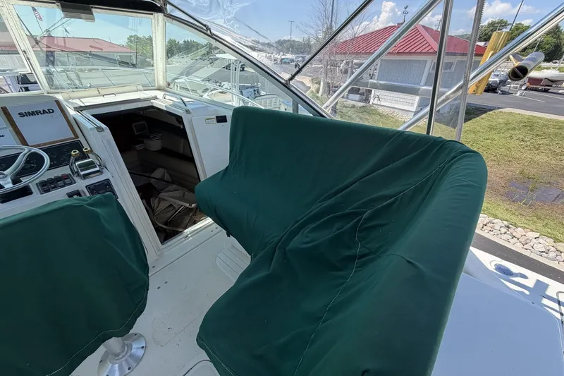 Slide: The Image of 1998 Pursuit 3400 Express boat cockpit with green seat covers and navigation equipment. - 14