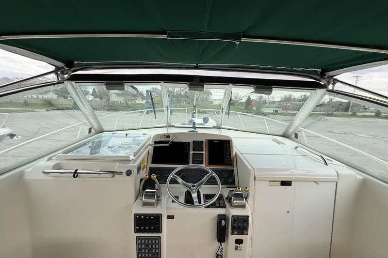Slide: The Image of Cockpit view of a 1998 Pursuit 3400 Express boat with steering wheel and controls. - 9