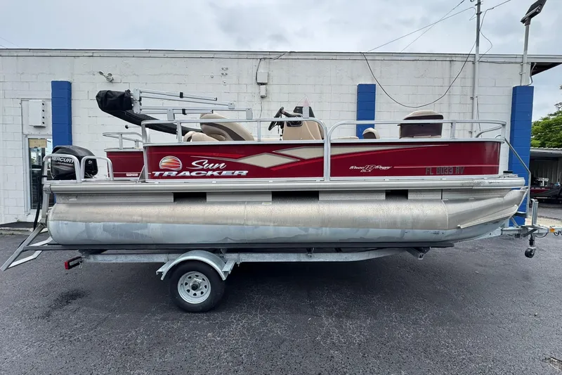 The Image of 2019 Sun Tracker Bass Buggy 18 DLX pontoon boat on trailer, parked outdoors. - 1