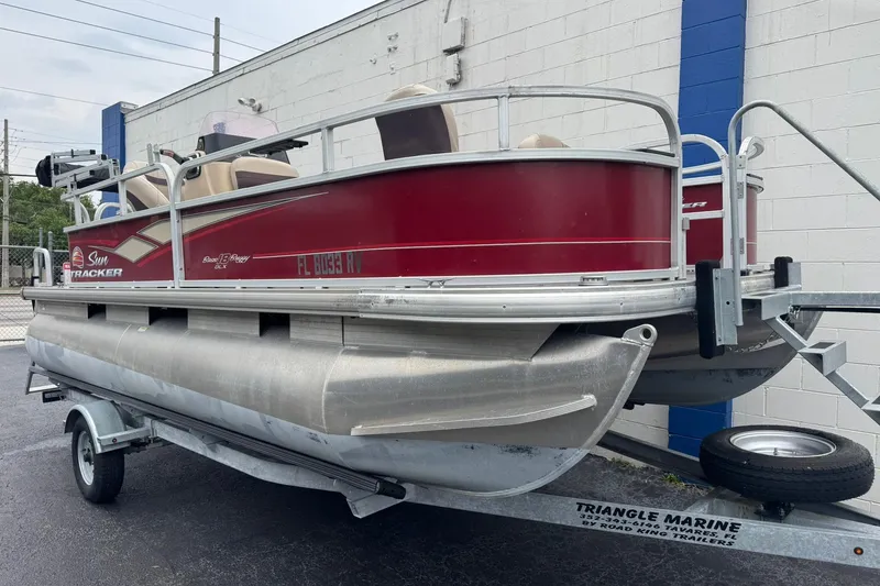 Slide: The Image of 2019 Sun Tracker Bass Buggy 18 DLX pontoon boat on trailer, parked outside. - 3