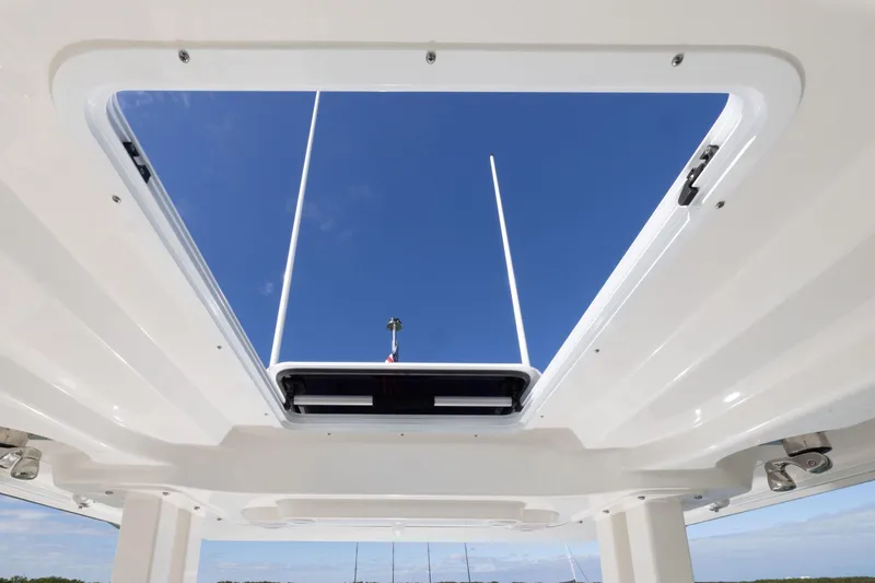 Slide: The Image of 2026 Pursuit S 328 Sport boat roof hatch with clear blue sky view. - 12