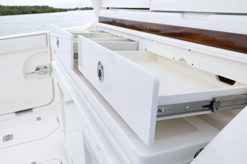 Slide: The Image of Open storage drawers on a 2026 Pursuit S 328 Sport boat, showcasing sleek design. - 14