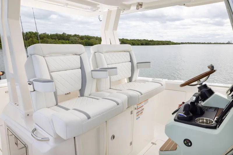 Slide: The Image of Luxury seating and helm of 2026 Pursuit S 328 Sport boat on calm water. - 15