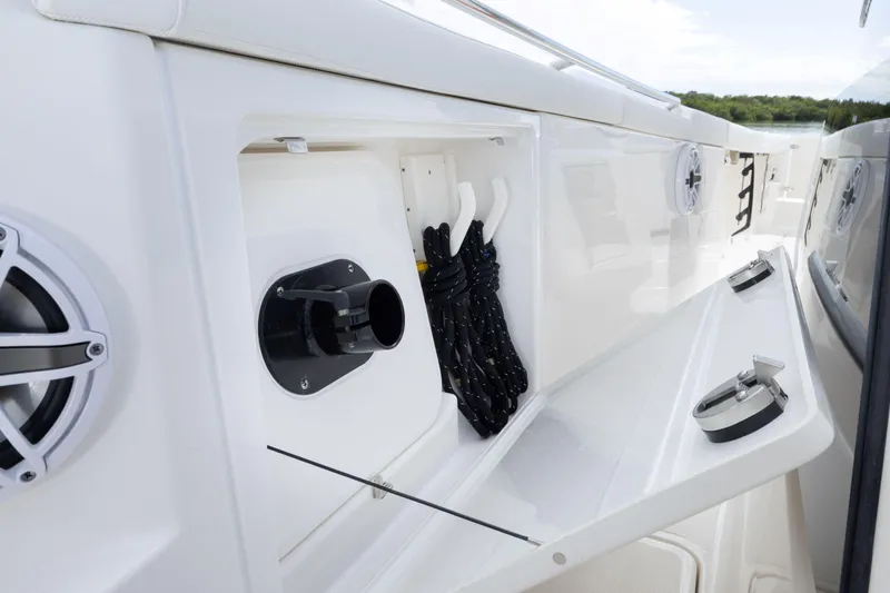 Slide: The Image of 2026 Pursuit S 328 Sport boat storage compartment with speakers and rope hangers. - 19