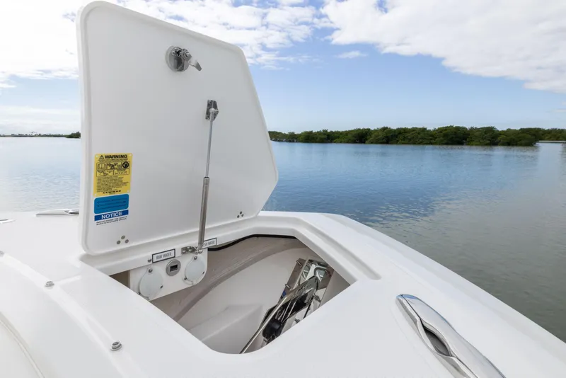 Slide: The Image of 2026 Pursuit S 328 Sport boat anchor compartment open on calm water. - 28