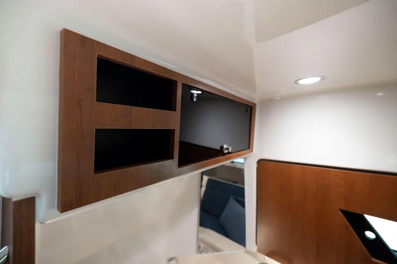 Slide: The Image of Interior of 2026 Pursuit S 328 Sport boat with wooden cabinetry and modern lighting. - 31