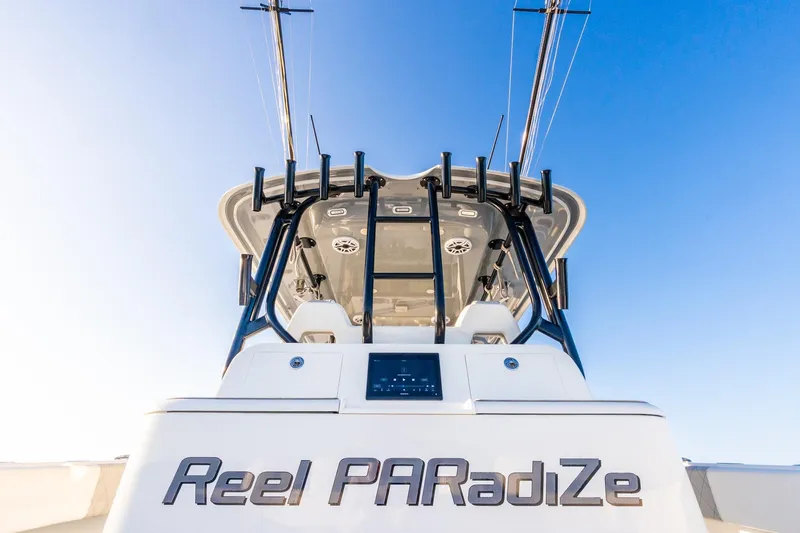 Slide: The Image of Freeman 42LR 2022 boat "Reel PARadiZe" with fishing rods against clear blue sky. - 23