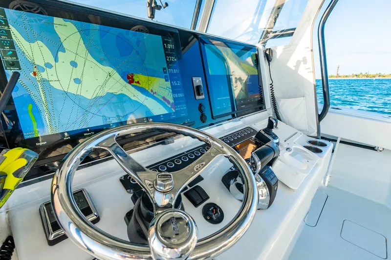 Slide: The Image of Freeman 42LR 2022 boat cockpit with navigation screens and steering wheel on open water. - 27