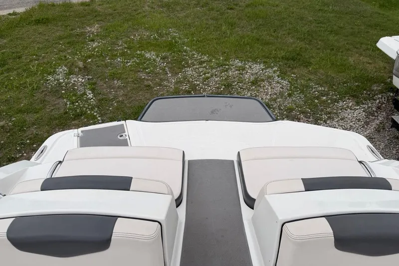 Slide: The Image of 2018 Chaparral Vortex 223 VRX boat interior with cushioned seating and grassy background. - 11