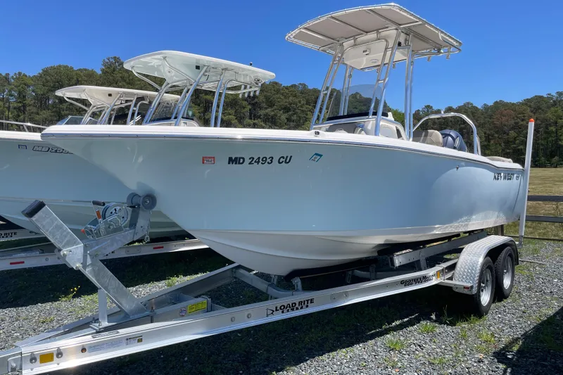 The Image of 2023 Key West 203 FS boat on trailer, parked outdoors under clear blue sky. - 0
