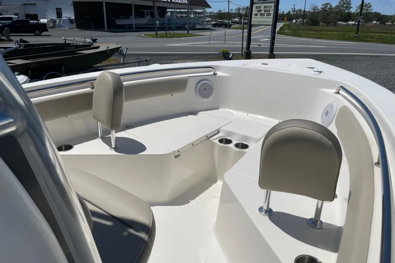 Slide: The Image of 2023 Key West 203 FS boat interior with seating and cup holders, displayed outdoors. - 11