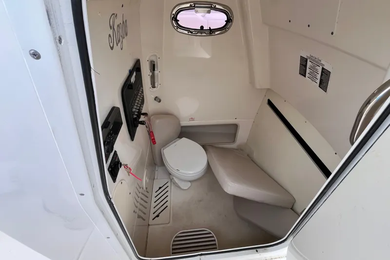 Slide: The Image of Interior of 2020 Boston Whaler 280 Outrage boat, featuring compact marine toilet. - 12