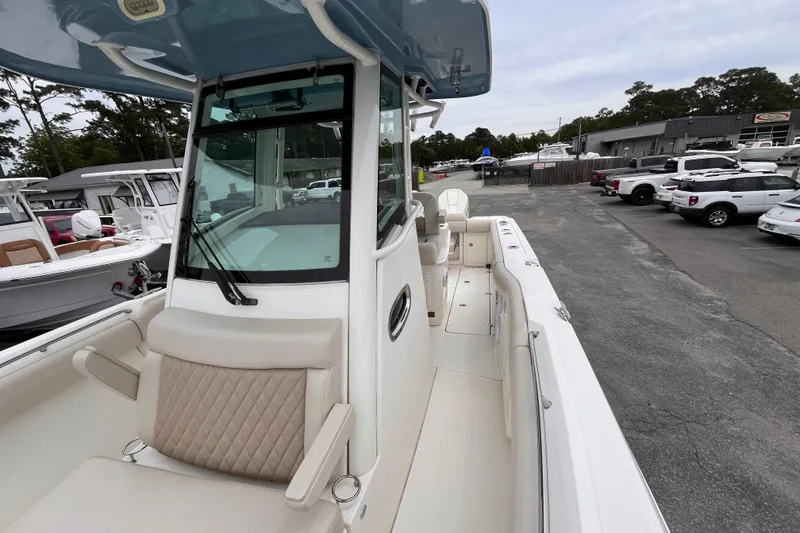 Slide: The Image of 2020 Boston Whaler 280 Outrage boat interior, showcasing seating and helm area in a marina. - 15