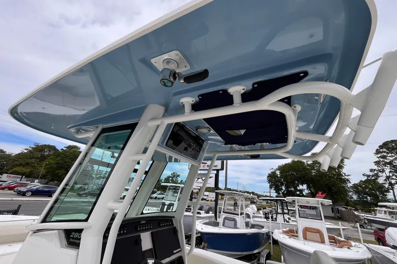 Slide: The Image of 2020 Boston Whaler 280 Outrage boat with blue hardtop and console, displayed outdoors. - 17