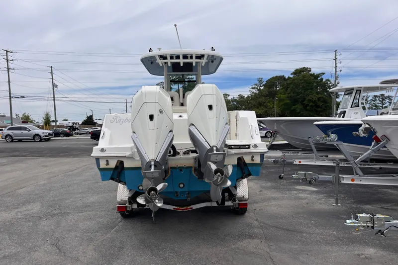 Slide: The Image of 2020 Boston Whaler 280 Outrage boat with dual outboard motors in a parking lot. - 3