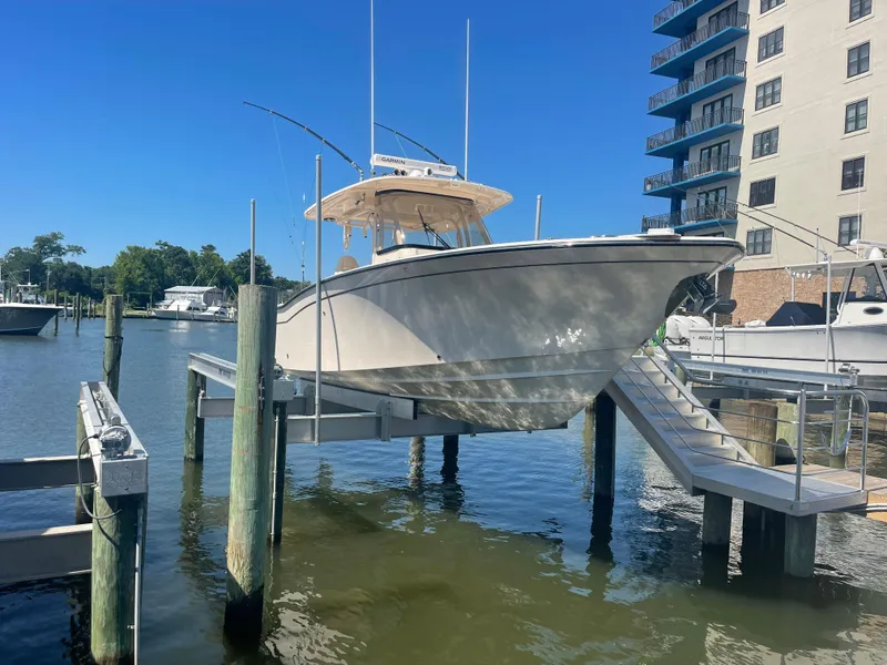 Slide: The Image of 2021 Grady-White Canyon 326 boat on a lift at the dock. - 2