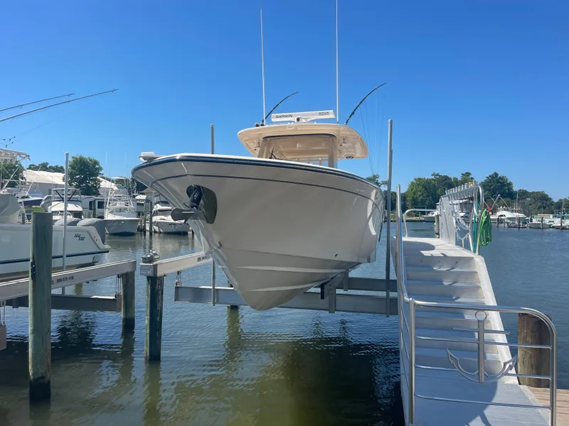 Slide: The Image of 2021 Grady-White Canyon 326 boat on a lift at the dock. - 3