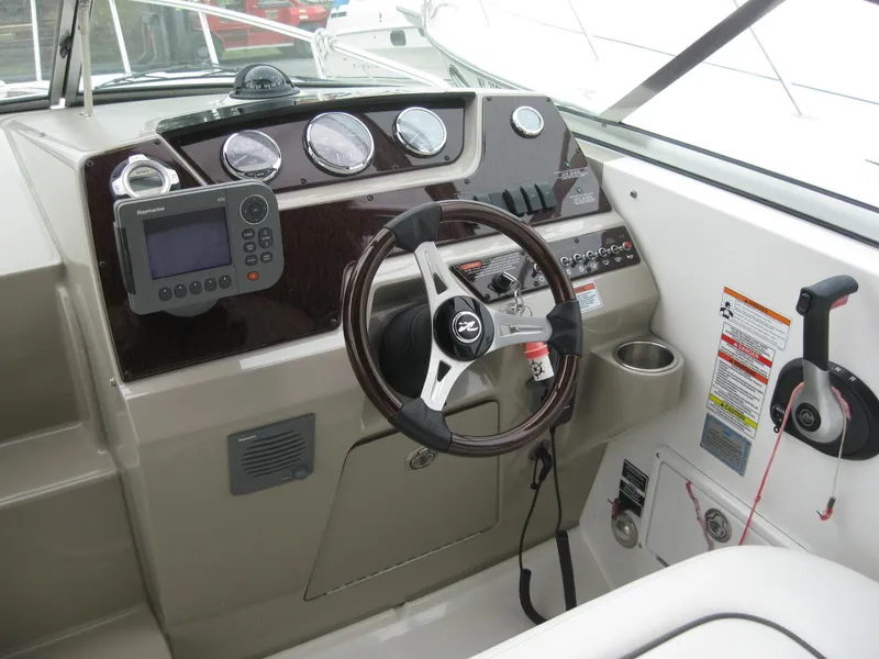 Slide: The Image of 2009 Sea Ray 270 Sundancer helm with instruments and steering wheel. - 15