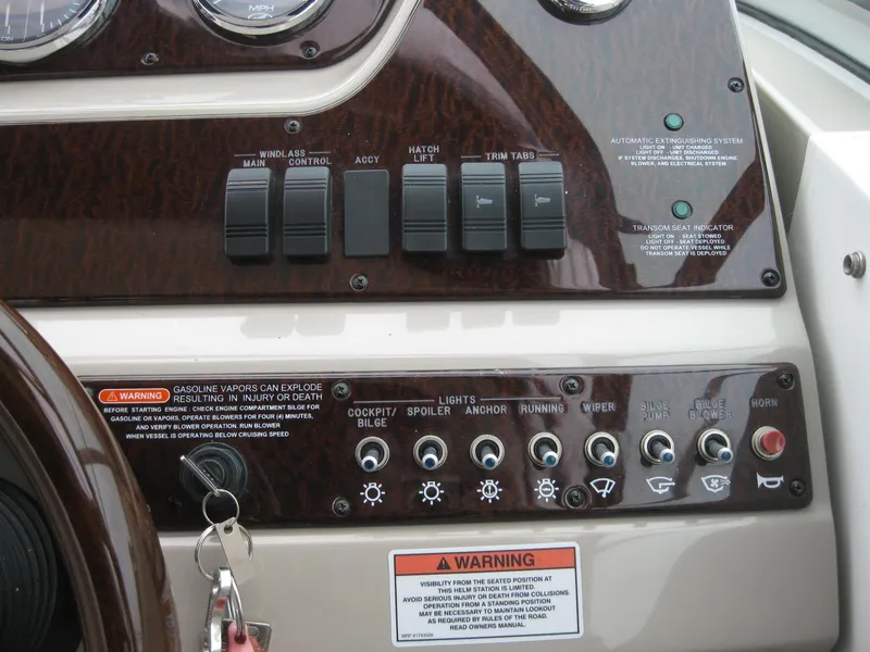 Slide: The Image of Dashboard of a 2009 Sea Ray 270 Sundancer boat with switches and warning labels. - 17
