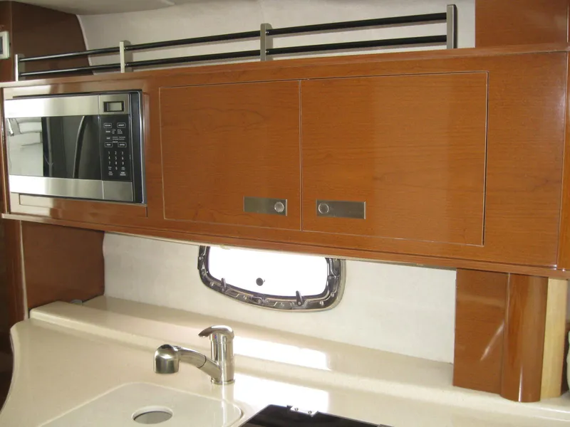 Slide: The Image of Interior of 2009 Sea Ray 270 Sundancer with microwave and wooden cabinets. - 24
