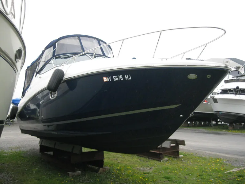 Slide: The Image of 2009 Sea Ray 270 Sundancer boat on blocks in a parking area. - 4