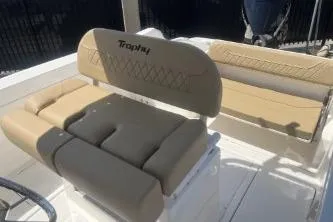 Slide: The Image of 2023 Trophy T24 CC boat interior with beige seating and steering wheel. - 11