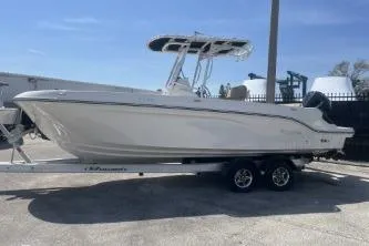 Slide: The Image of 2023 Trophy T24 CC boat on trailer, parked outdoors under clear blue sky. - 5