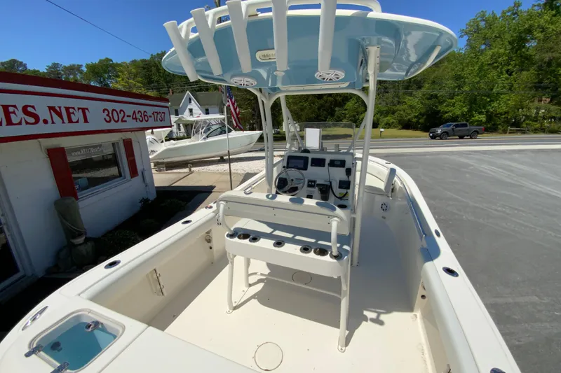 Slide: The Image of 2021 Cobia 220 Center Console boat with T-top and control panel, parked near dealership. - 11