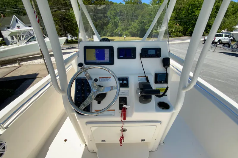 Slide: The Image of 2021 Cobia 220 Center Console boat dashboard with steering wheel and navigation equipment. - 12