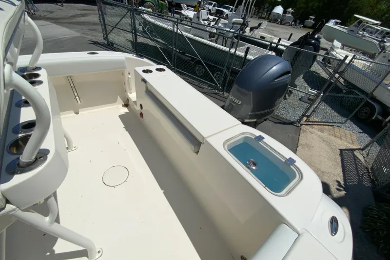 Slide: The Image of 2021 Cobia 220 Center Console boat interior with Yamaha engine, docked outdoors. - 16