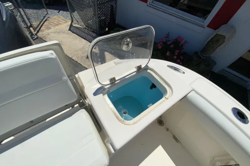 Slide: The Image of 2021 Cobia 220 Center Console boat with open storage compartment and seating area. - 18