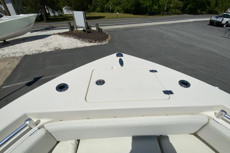 Slide: The Image of 2021 Cobia 220 Center Console boat bow with storage hatch and seating. - 22