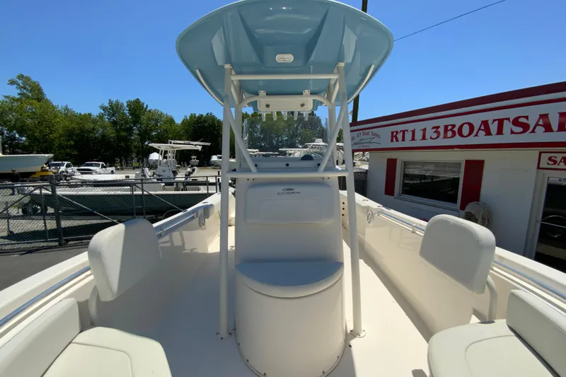Slide: The Image of 2021 Cobia 220 Center Console boat at dealership, featuring spacious seating and modern design. - 24