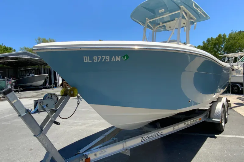 Slide: The Image of 2021 Cobia 220 Center Console boat on trailer, blue hull, sunny day. - 5