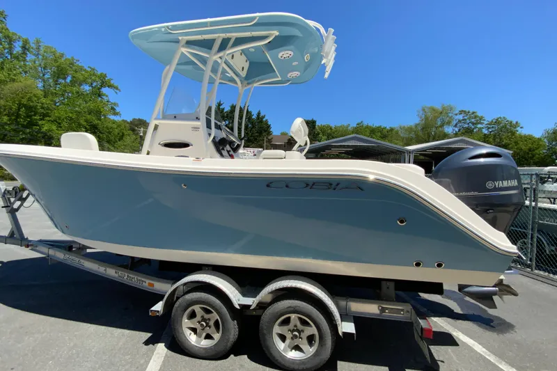 Slide: The Image of 2021 Cobia 220 Center Console boat on trailer with Yamaha engine, parked outdoors. - 7