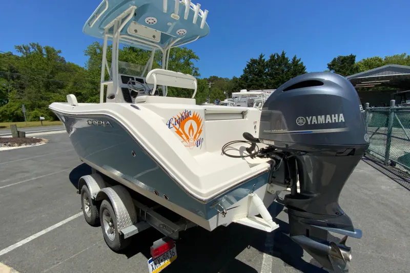 Slide: The Image of 2021 Cobia 220 Center Console boat with Yamaha outboard motor in a parking lot. - 8