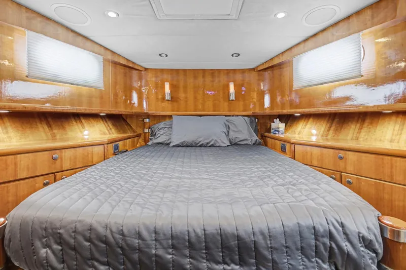 Slide: The Image of Luxurious cabin interior of 2004 Queenship 76 Baretta yacht with wood paneling and cozy bedding. - 18
