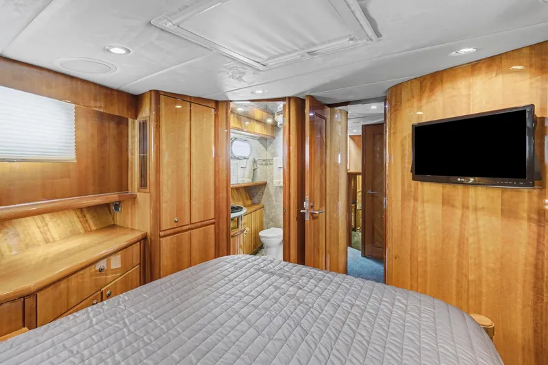 Slide: The Image of Luxurious 2004 Queenship 76 Baretta yacht bedroom with wood paneling and modern amenities. - 19