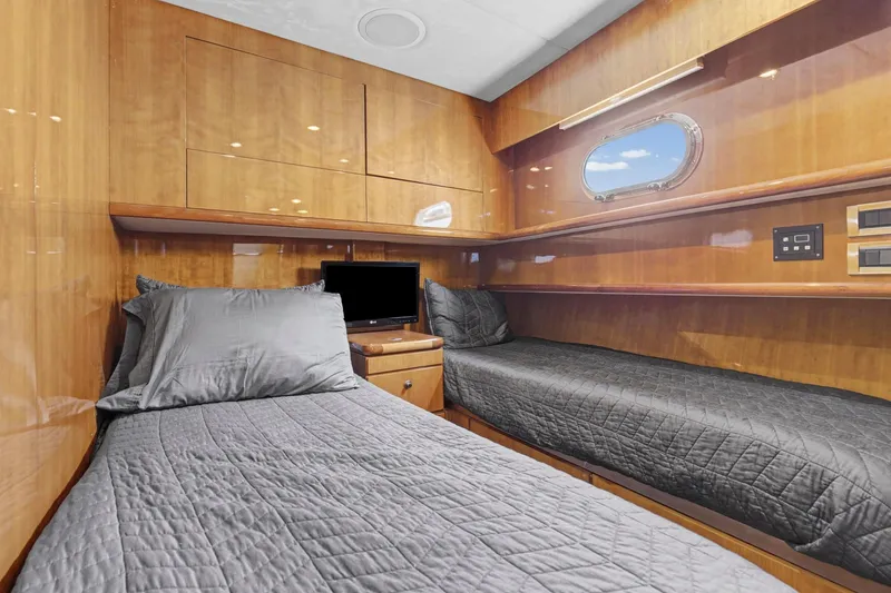 Slide: The Image of Luxurious cabin interior of 2004 Queenship 76 Baretta yacht with twin beds and porthole. - 21