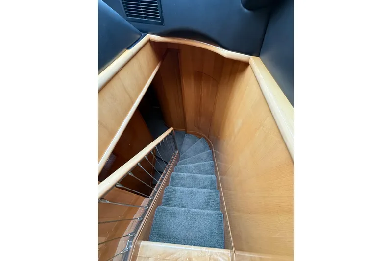 Slide: The Image of Staircase inside 2004 Queenship 76 Baretta yacht, featuring wooden railings and carpeted steps. - 48