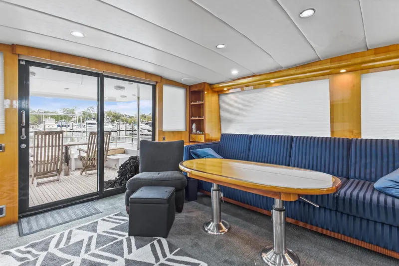 Slide: The Image of Luxurious interior of 2004 Queenship 76 Baretta yacht with elegant seating and marina view. - 6