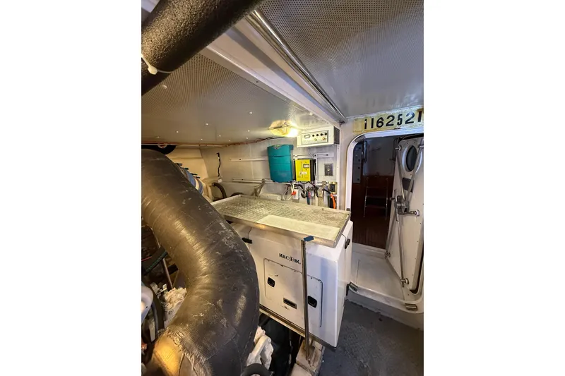 Slide: The Image of Engine room of 2004 Queenship 76 Baretta yacht, featuring equipment and control panels. - 66