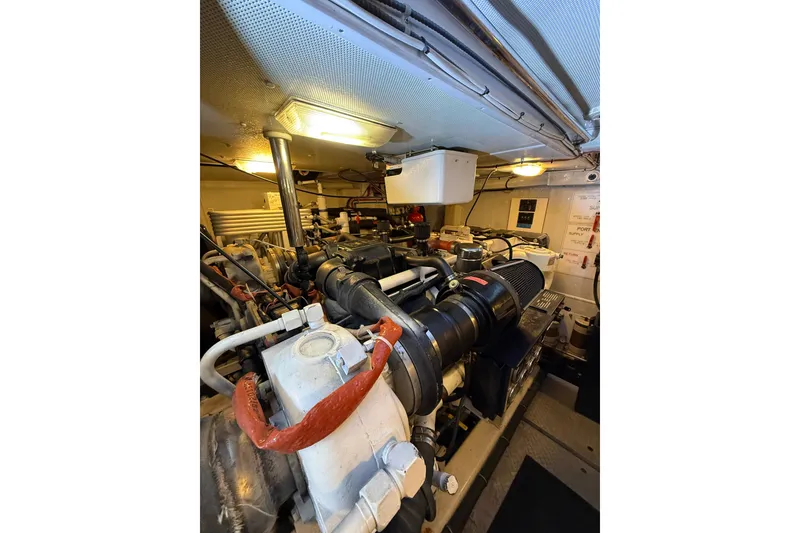 Slide: The Image of Engine room of 2004 Queenship 76 Baretta yacht, showcasing mechanical components and lighting. - 68