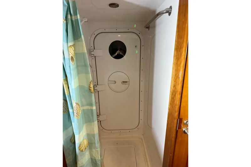 Slide: The Image of Shower area with nautical-themed curtain in 2004 Queenship 76 Baretta yacht. - 70