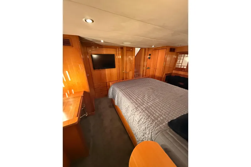 Slide: The Image of Luxurious bedroom interior of 2004 Queenship 76 Baretta yacht with wood paneling and TV. - 73