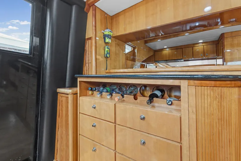 Slide: The Image of Luxurious wooden interior of 2004 Queenship 76 Baretta yacht with wine storage. - 9