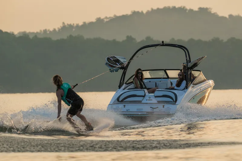 Slide: The Image of Manufacturer Provided Image: 2026 Yamaha AR195 boat towing a wakeboarder on a serene lake at sunset. - 3
