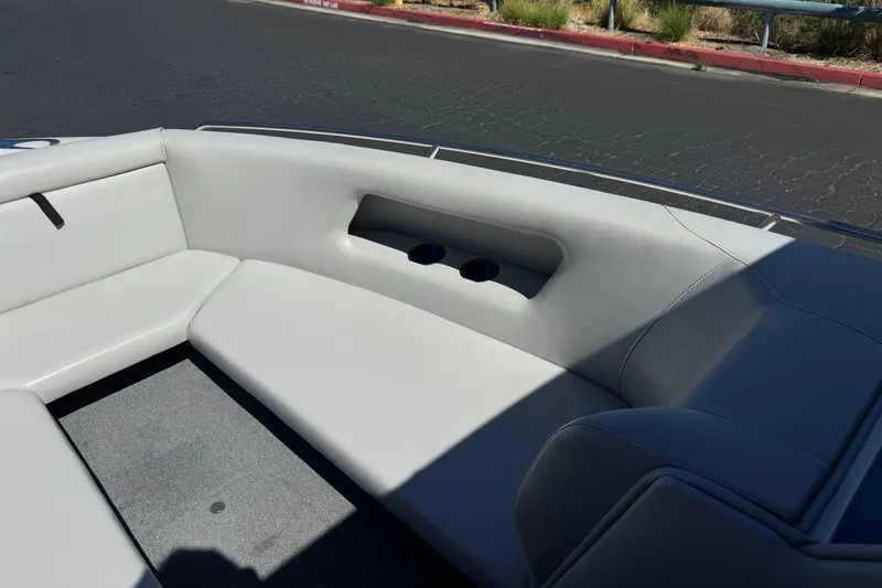 Slide: The Image of Interior of a 2007 Commander 2300LX boat with white seating and cup holders. - 10