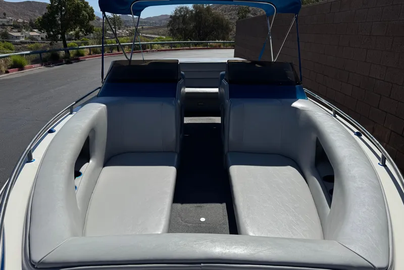 Slide: The Image of 2007 Commander 2300LX boat interior with gray seating and blue canopy. - 11